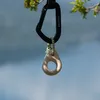 Klettergriff "Mono" von YY Vertical; hängend an einem Karabiner; vor einer natürlichen Landschaft. Produktbild-Vorschau