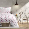 A bedroom scene with a bed dressed in heart-patterned bedding, a chair, and decorative branches. Produktbild-Vorschau