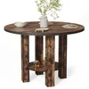 A round wooden dining table with a rustic finish and four sturdy legs, featuring a lower shelf with two small jars of honey. Voir les images du produit