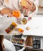 Collage, die quadratische Glas-Gewürzgläser mit Bambusdeckeln zeigt, gefüllt mit verschiedenen Gewürzen, verwendet und in einer Schublade aufbewahrt Anteprima dell’immagine prodotto