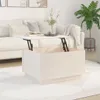 A white lift-top coffee table is shown in a living room setting with a sofa and a plant. Voir les images du produit