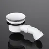 A white shower drain assembly with a silver cap and a white angled pipe is shown against a dark gray background with a reflection. Produktbild-Vorschau