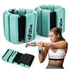 A woman is shown wearing wrist weights while stretching her arm. Podgląd zdjęcia produktu