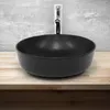 A black ceramic sink with a chrome faucet, placed on a wooden countertop against a concrete wall. Náhled obrázku produktu