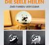 A collage of images showcasing a ferrofluid lamp and speaker, with text indicating features and color options. Produktbild-Vorschau