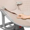 A close-up shot of a baby bouncer with a hand adjusting the fabric. Produktbild-Vorschau