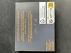 A close-up of a dark gray cardboard box with text and symbols printed on it. Produktbild-Vorschau