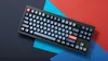 A keyboard is placed on a background of red, blue, and dark gray paper. Náhľad obrázku produktu