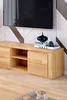 A modern living room setup featuring a wooden TV stand with decorative items and a television mounted above it. Produktbild-Vorschau