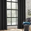 A dark gray curtain hangs beside a window, with a chair and cushions in the foreground. Produktbild-Vorschau