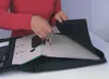 A person is shown placing a binder into a black organizer bag. Náhľad obrázku produktu