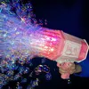 Pinke Bazok-Blasenpistole, von einer Hand gehalten, erzeugt einen Strom farbenfroher, leuchtender Blasen vor dunklem Hintergrund Náhled obrázku produktu
