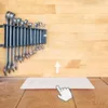 A set of wrenches mounted on a rack on a wooden wall, with a white rectangular object and a cursor in the foreground. Produktbild-Vorschau