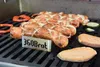 Sausages, vegetables, and sweet potato slices are grilling on a barbecue. Produktbild-Vorschau