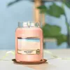 A lit Yankee Candle in a glass jar with a label showing a beach scene. Podgląd zdjęcia produktu