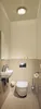 A clean and modern bathroom with a wall-hung toilet and a small sink. Anteprima dell’immagine prodotto