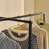 Several sweaters and a shirt are hanging on a clothing rack. Produktbild-Vorschau