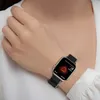 A person wearing a white shirt and a smartwatch on their wrist. Náhled obrázku produktu
