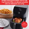 An air fryer with a whole chicken and vegetables inside, next to a plate of french fries. Produktbild-Vorschau