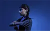 A woman with braided hair is shown in profile against a blue background, with her arm across her chest. Produktbild-Vorschau