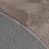 A close-up view of the underside and top of a round rug, showing the texture of the faux fur and the woven backing. Anteprima dell’immagine prodotto