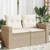 A beige two-seater outdoor sofa with cushions, placed on a rug with plants and curtains in the background. Produktbild-Vorschau