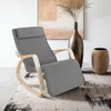 A rocking chair is placed on a rug in a room with a large vase and artwork in the background. Náhled obrázku produktu