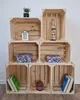 A display of wooden crates stacked and filled with decorative items, books, and boxes. Produktbild-Vorschau
