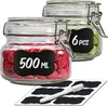 Two glass jars with clamp lids, one filled with red berries and labeled '500 ML', the other filled with green items and labeled '6 PCS'. A set of chalk-style labels and a marker are shown in the foreground. Náhled obrázku produktu