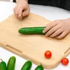 Hands are shown preparing a cucumber on a wooden cutting board, with cherry tomatoes and other cucumbers visible. Produktbild-Vorschau