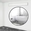 A modern bathroom with a freestanding bathtub reflected in a large round mirror. Produktbild-Vorschau