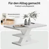 A white coffee table with a book and vases on it, with a background image of glasses of water and text overlays. Produktbild-Vorschau