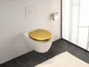A modern bathroom with a wall-mounted toilet featuring a gold seat. Produktbild-Vorschau