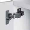 A close-up view of a cabinet hinge attached to a white cabinet. Produktbild-Vorschau