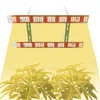 Two LED grow lights are suspended above a group of plants, casting a yellow glow. Náhľad obrázku produktu