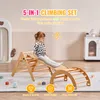 A young girl is playing on a wooden climbing set indoors. Produktbild-Vorschau