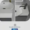 A split image showing two views of a white ceramic sink with a black faucet, mounted on a dark gray cabinet. Below the sink images, there are icons and text indicating product quality and origin. Produktbild-Vorschau