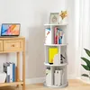 A white rotating bookshelf filled with books and decorative items, placed next to a wooden console table with a laptop. Produktbild-Vorschau