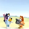 Two cartoon dog figurines, one blue and one orange, are standing in a field with a blue sky. Voir les images du produit
