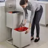 A woman is shown sorting waste into a multi-compartment recycling bin in a kitchen setting. Podgląd zdjęcia produktu
