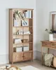 A wooden bookshelf filled with books and decorative items, placed in a room next to a console table. Náhľad obrázku produktu