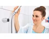 A woman is holding a shower head in a bathroom. Náhled obrázku produktu