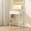 A white standing desk with a computer and keyboard set up, next to a window with curtains. A pegboard with some items hangs on the wall above the desk. Náhľad obrázku produktu