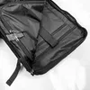 Close-up view of the interior of an open black backpack, showing compartments and zippers. Produktbild-Vorschau