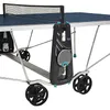 A close-up view of a blue outdoor table tennis table with black wheels and a black storage unit attached to the side. Produktbild-Vorschau