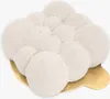A white, cloud-like dessert on a gold base. Produktbild-Vorschau