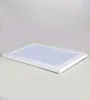 A white picture frame is shown lying flat on a light gray surface with a white background. Produktbild-Vorschau