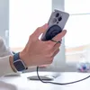 A person's hand holding a smartphone with a magnetic charger attached, while wearing a smartwatch. Anteprima dell’immagine prodotto