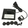 A solar panel kit for a mini fountain pump, including the solar panel, pump, and various nozzle attachments, laid out on a white background. Podgląd zdjęcia produktu