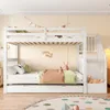 A white bunk bed with a pull-out trundle bed in a child's bedroom. Voir les images du produit